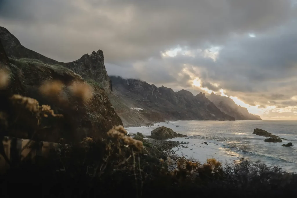 Costa y acantilados del norte de Tenerife al atardecer, paisaje natural para turismo sostenible.