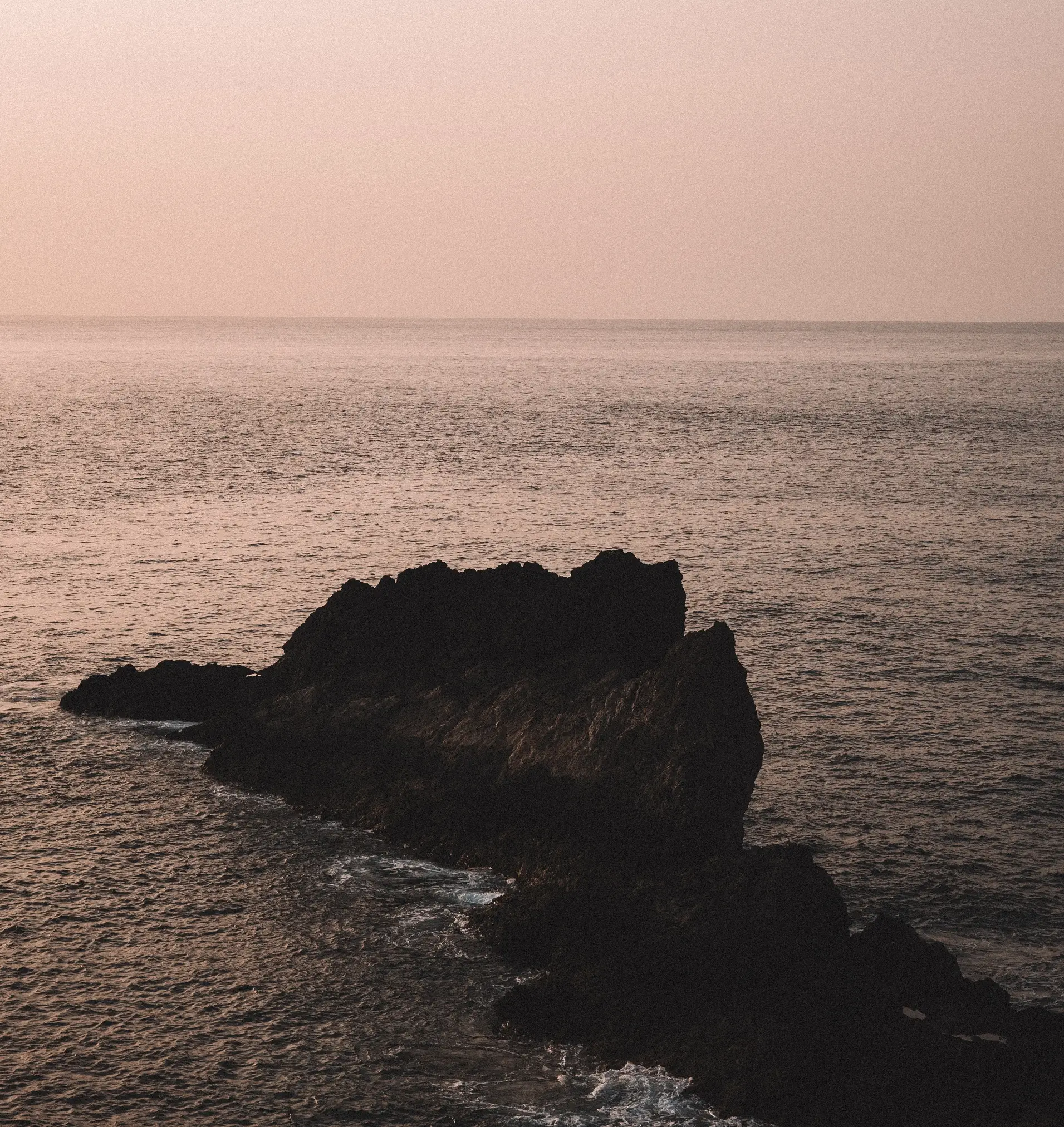 Costa rocosa al atardecer en Tenerife, naturaleza volcánica y turismo sostenible en Canarias.
