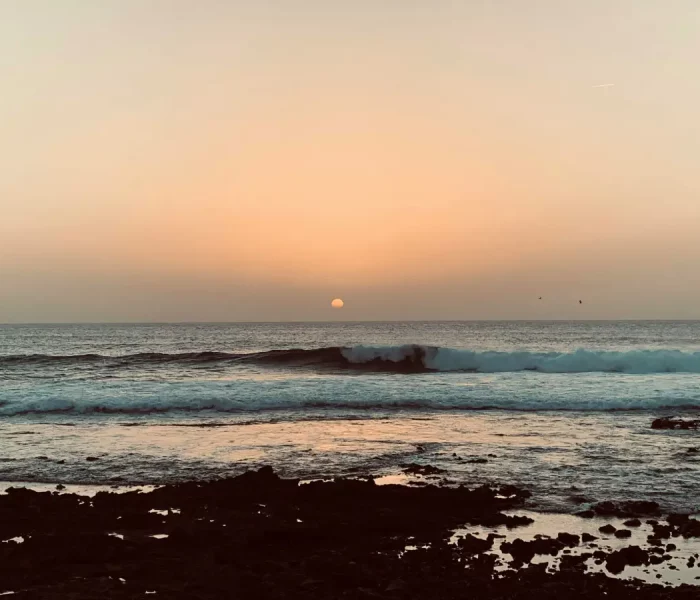 Puesta de sol sobre el océano Atlántico en la costa de Tenerife, experiencia de turismo sostenible.